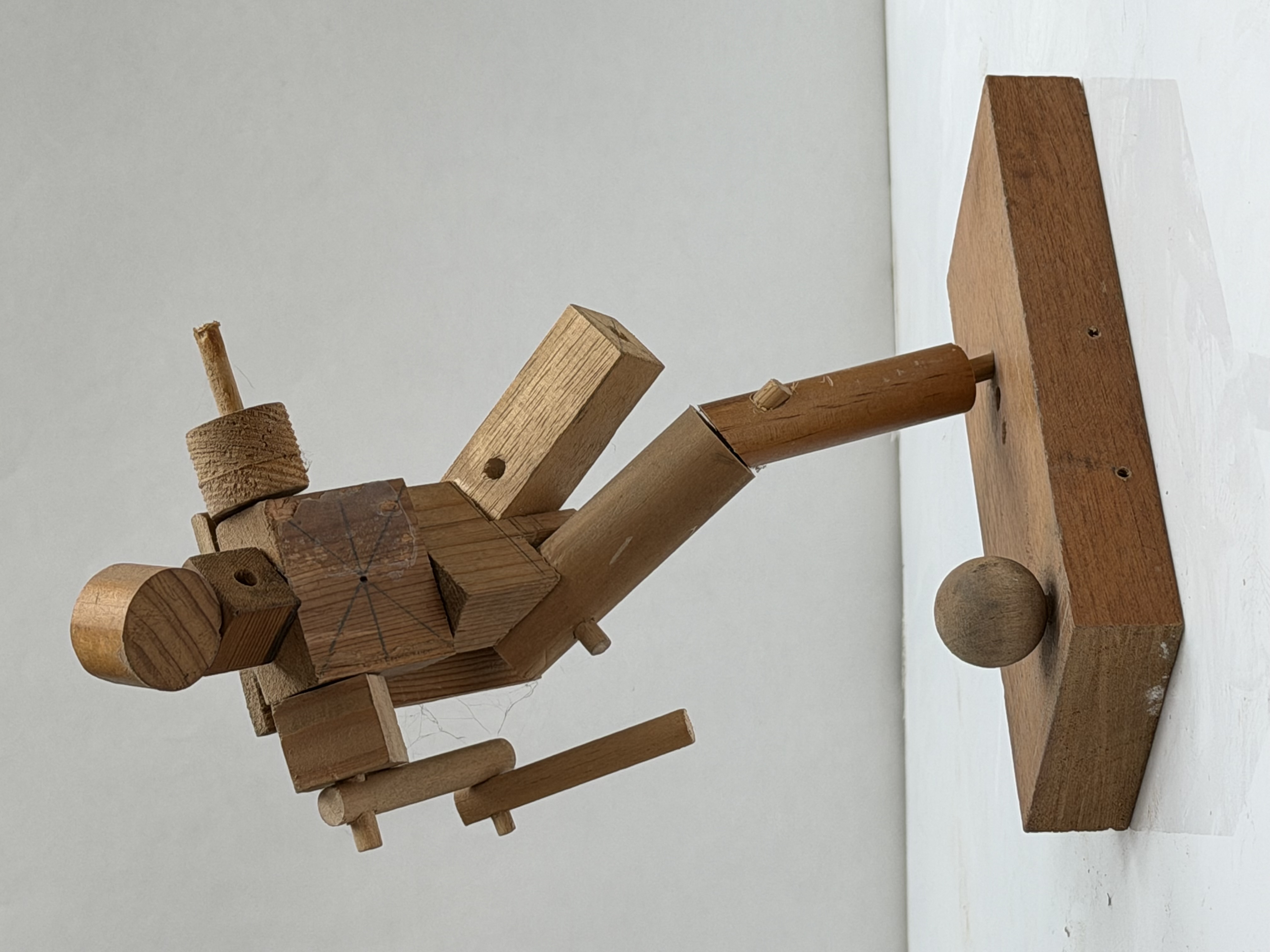 Figure, Kicking — a constructed wooden figure caught at the top of a kick